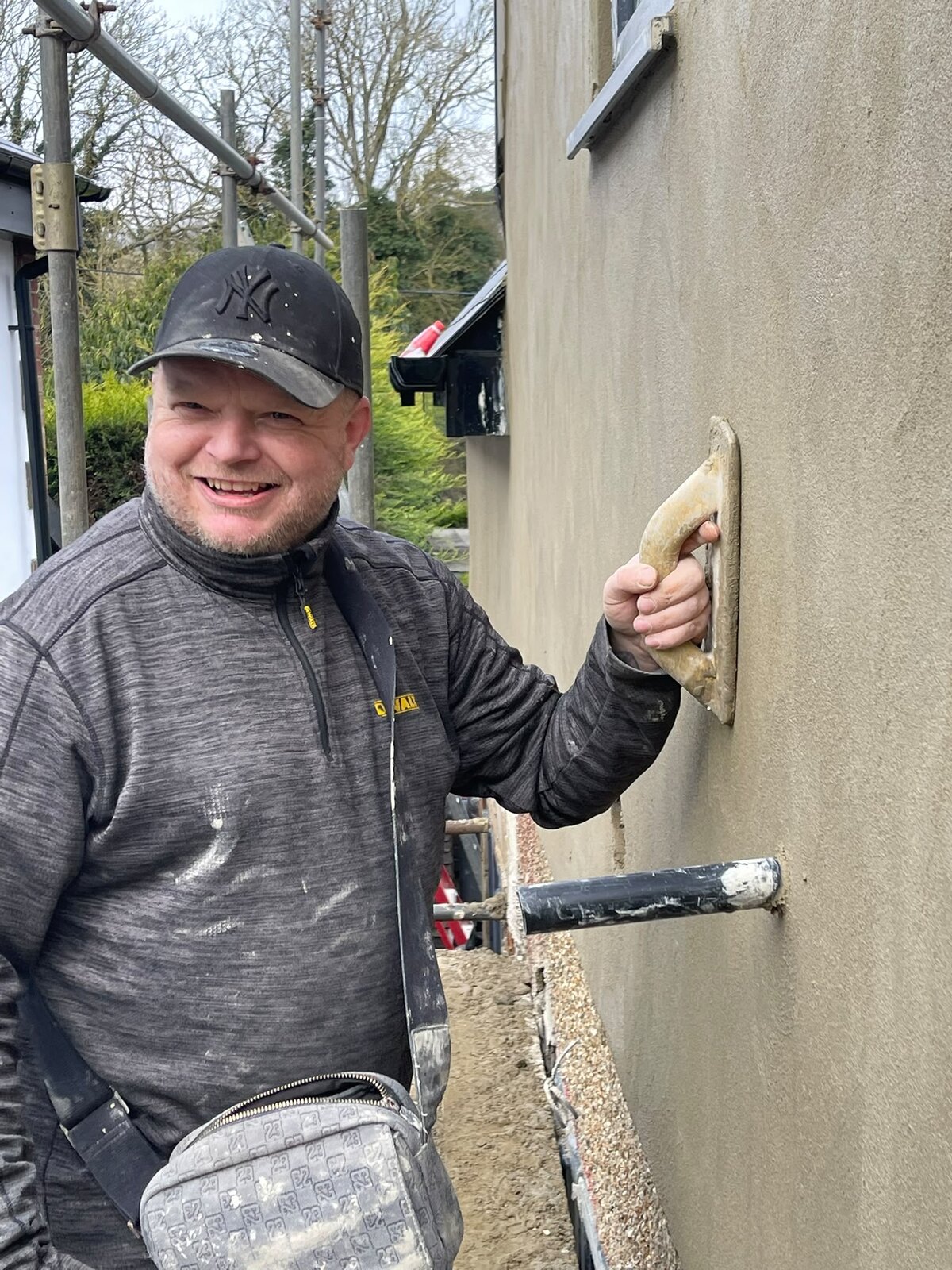 Wayne Weeks of Artisan Bespoke Walls and Floors hand-finishing a rendered wall on a live job across London and Kent
